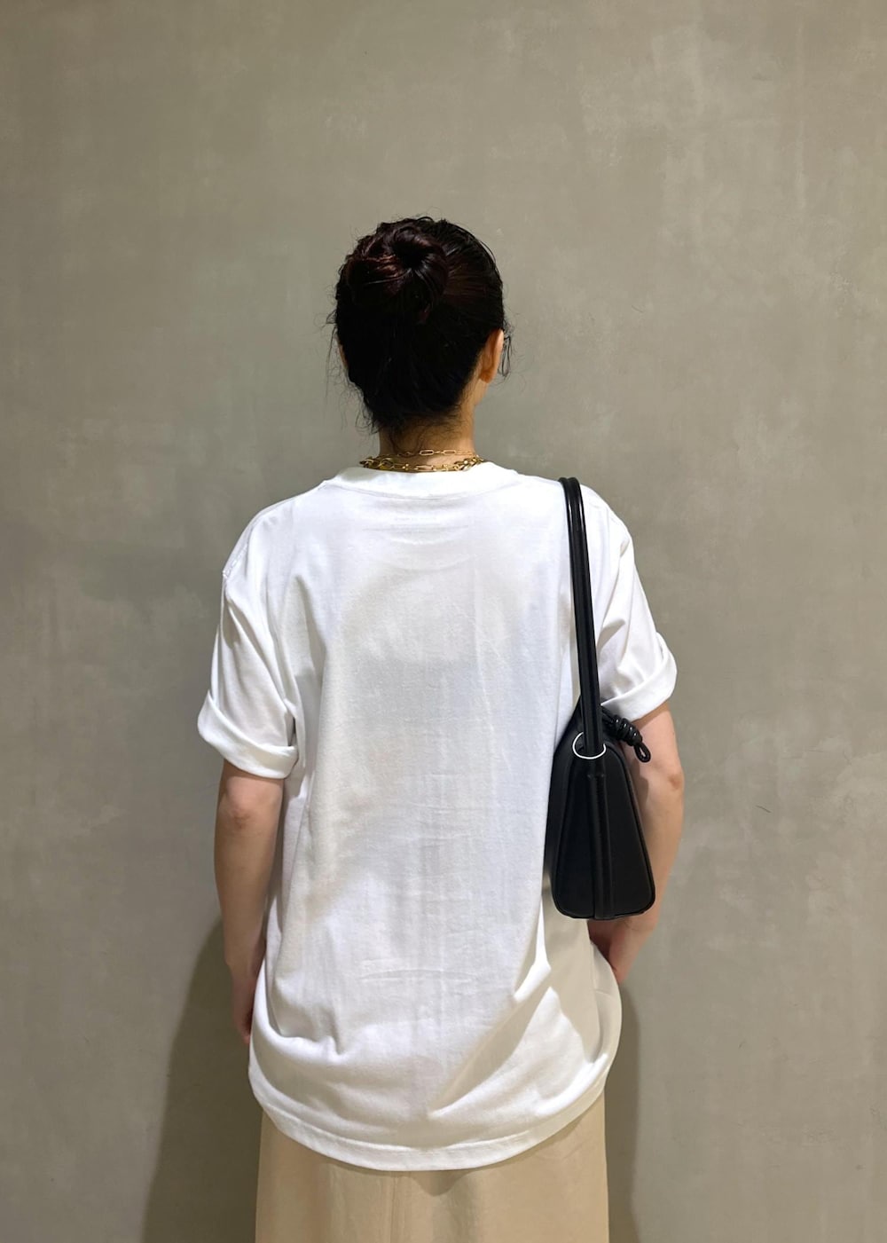 ブラック系のサンダル、ホワイト系のスカート、ブラック系のハンドバッグを着用したレディースの夏コーディネートの8枚目の写真