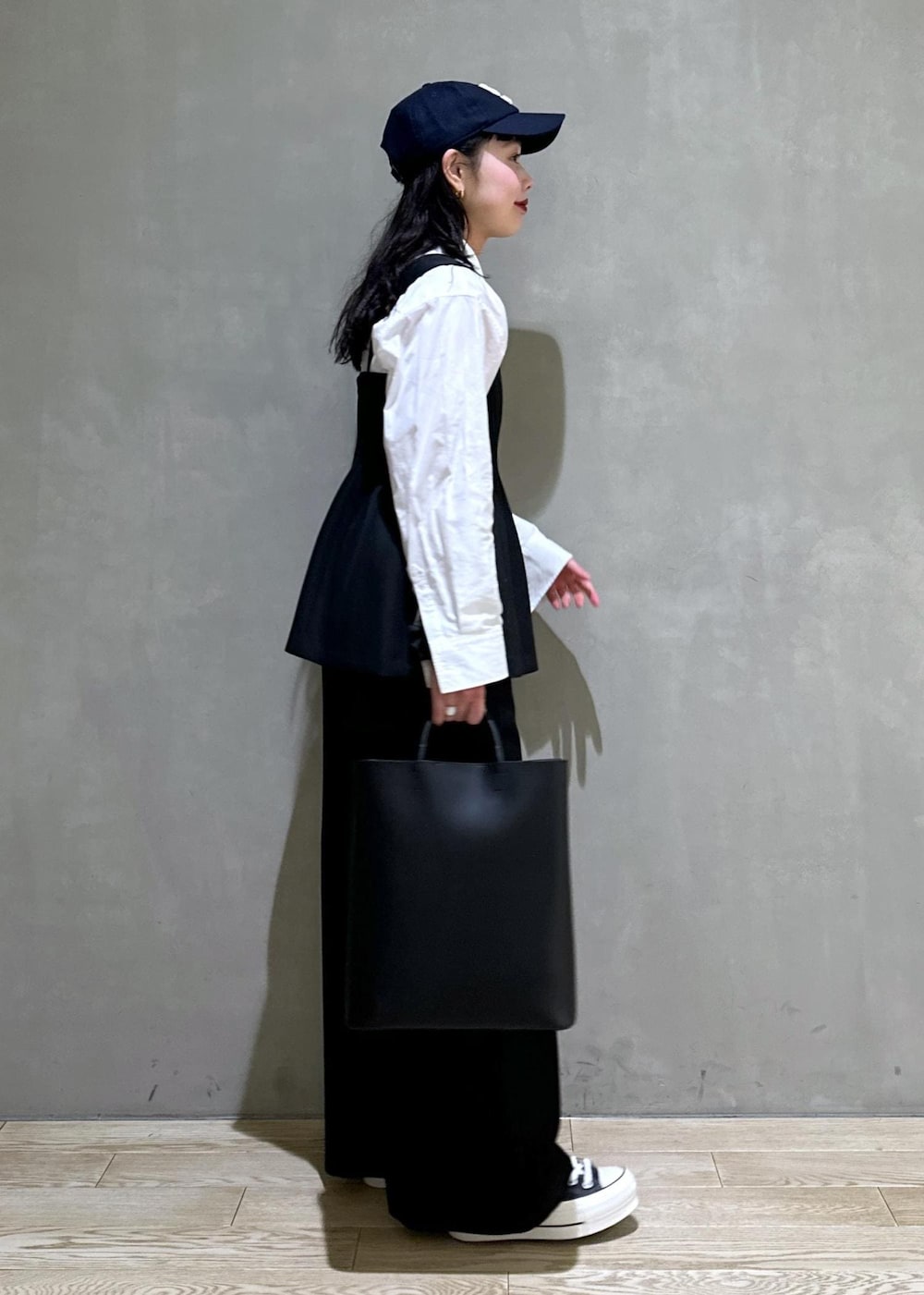 ブラック系のトートバッグ、ブラック系のつなぎ/オールインワンを着用したレディースの冬コーディネートの5枚目の写真