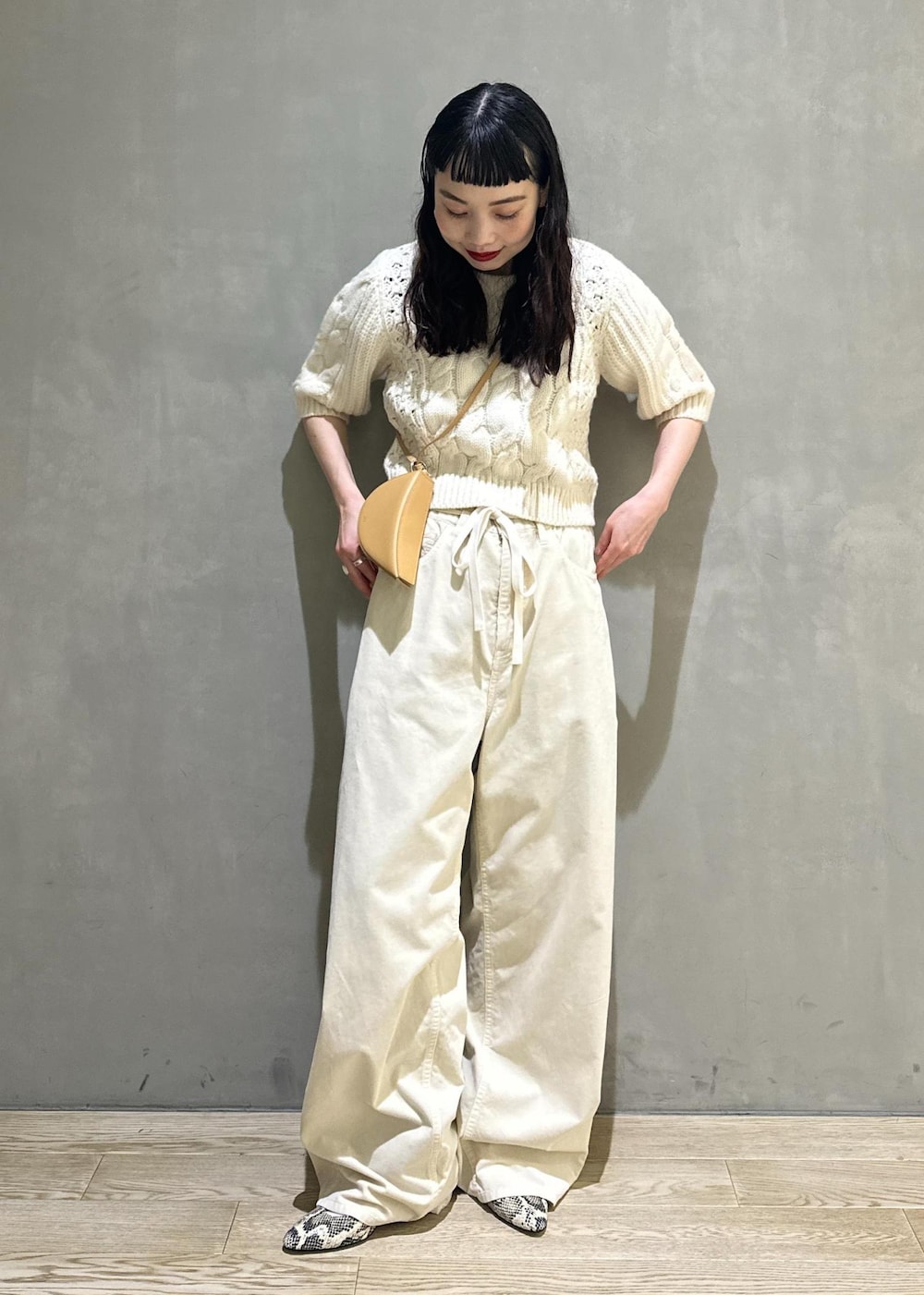 ホワイト系のその他パンツ、ホワイト系のニット/セーター、イエロー系のキーホルダーを着用したレディースの秋コーディネートの4枚目の写真