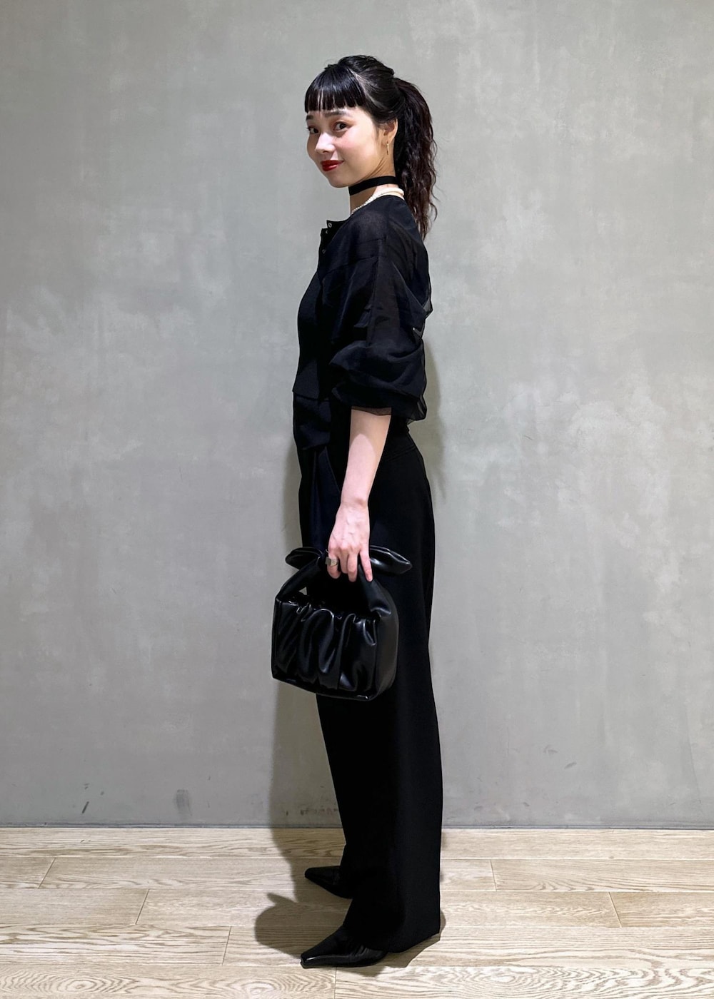 ブラック系のカーディガン/ボレロ、ブラック系のスラックス、ブラック系のショルダーバッグを着用したレディースの夏コーディネートの2枚目の写真