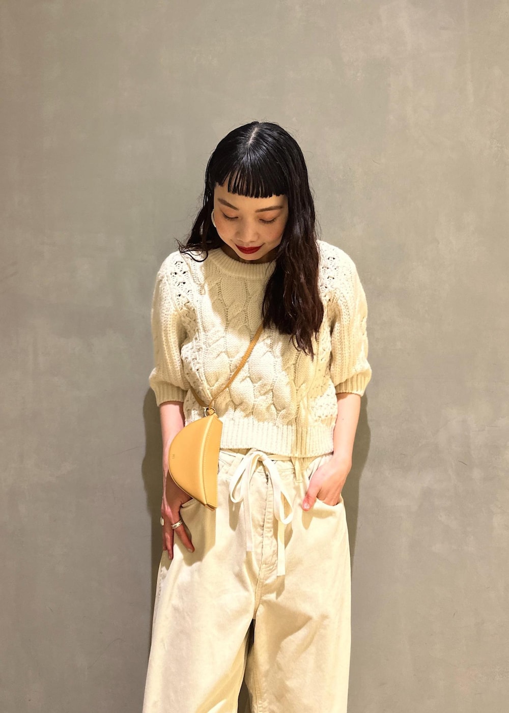 ホワイト系のその他パンツ、ホワイト系のニット/セーター、イエロー系のキーホルダーを着用したレディースの秋コーディネートの9枚目の写真