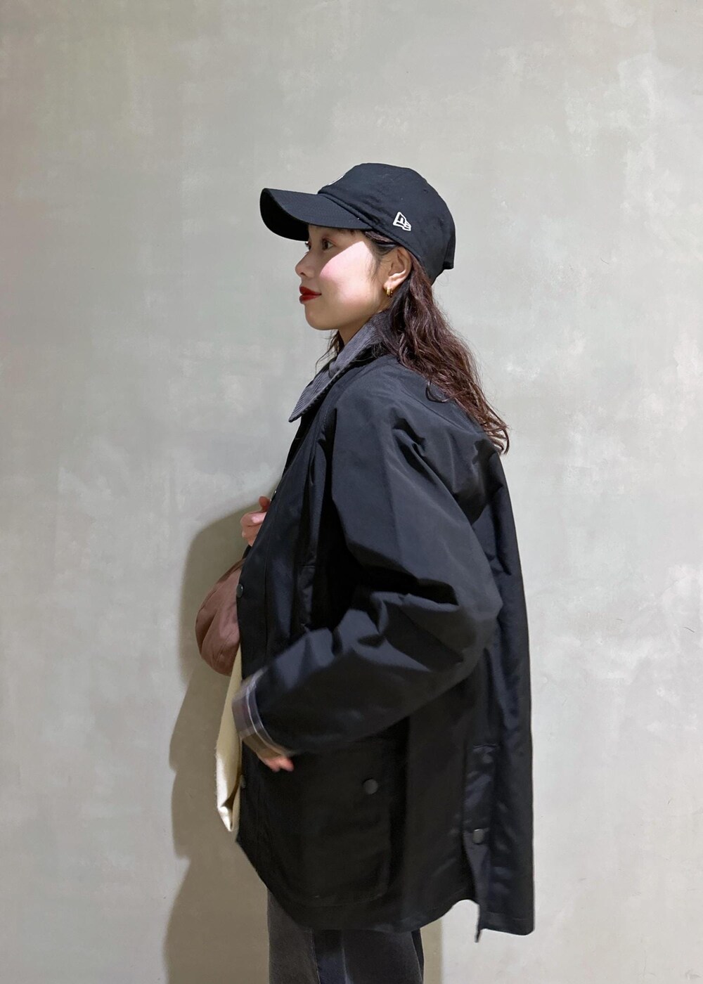 ブラック系のブルゾン、ブラック系のローファー、ブラック系のデニムパンツを着用したレディースの冬コーディネートの10枚目の写真