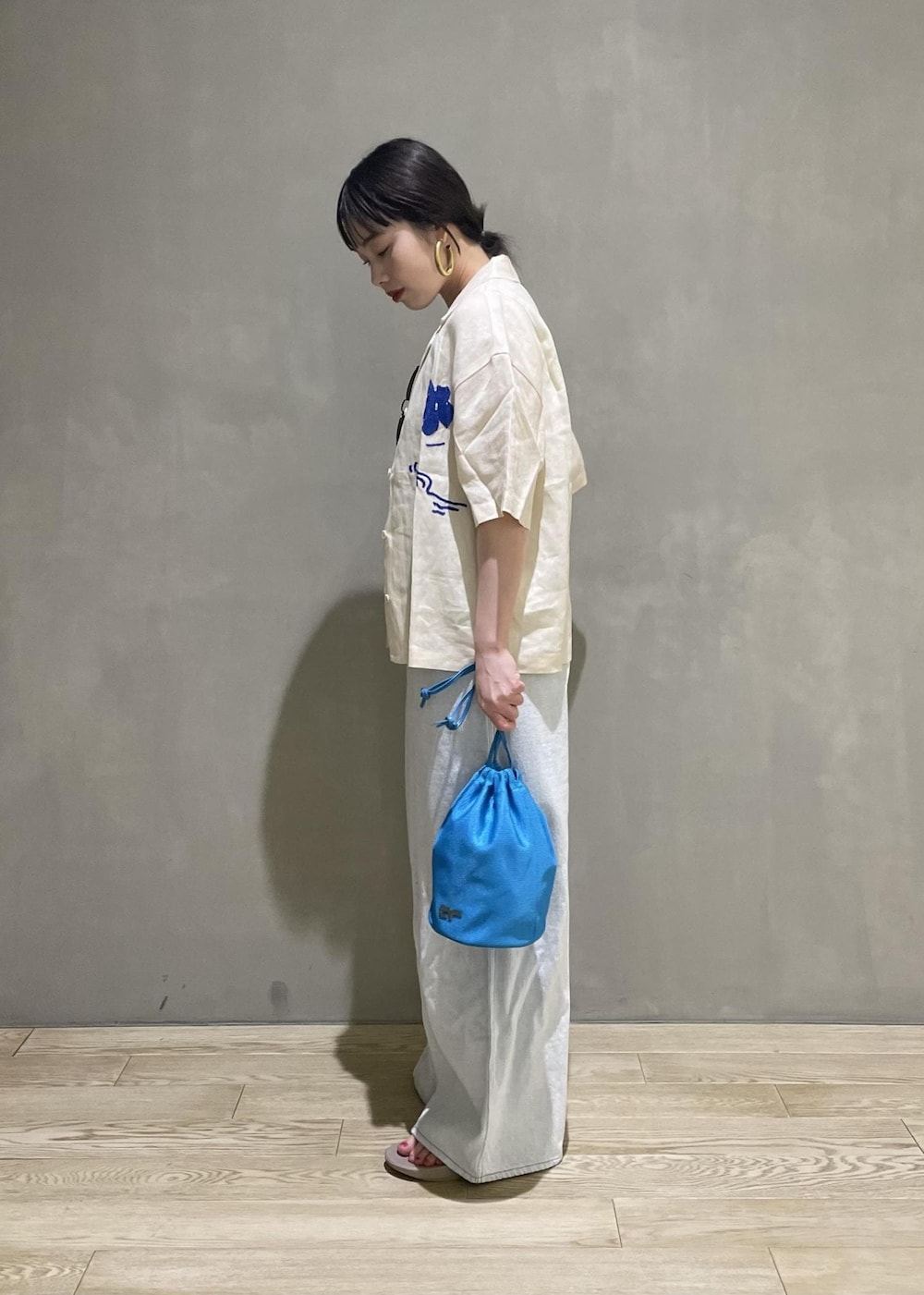 ホワイト系のサロペット/オーバーオール、ブルー系のショルダーバッグ、ベージュ系のサンダルを着用したレディースの春コーディネートの3枚目の写真