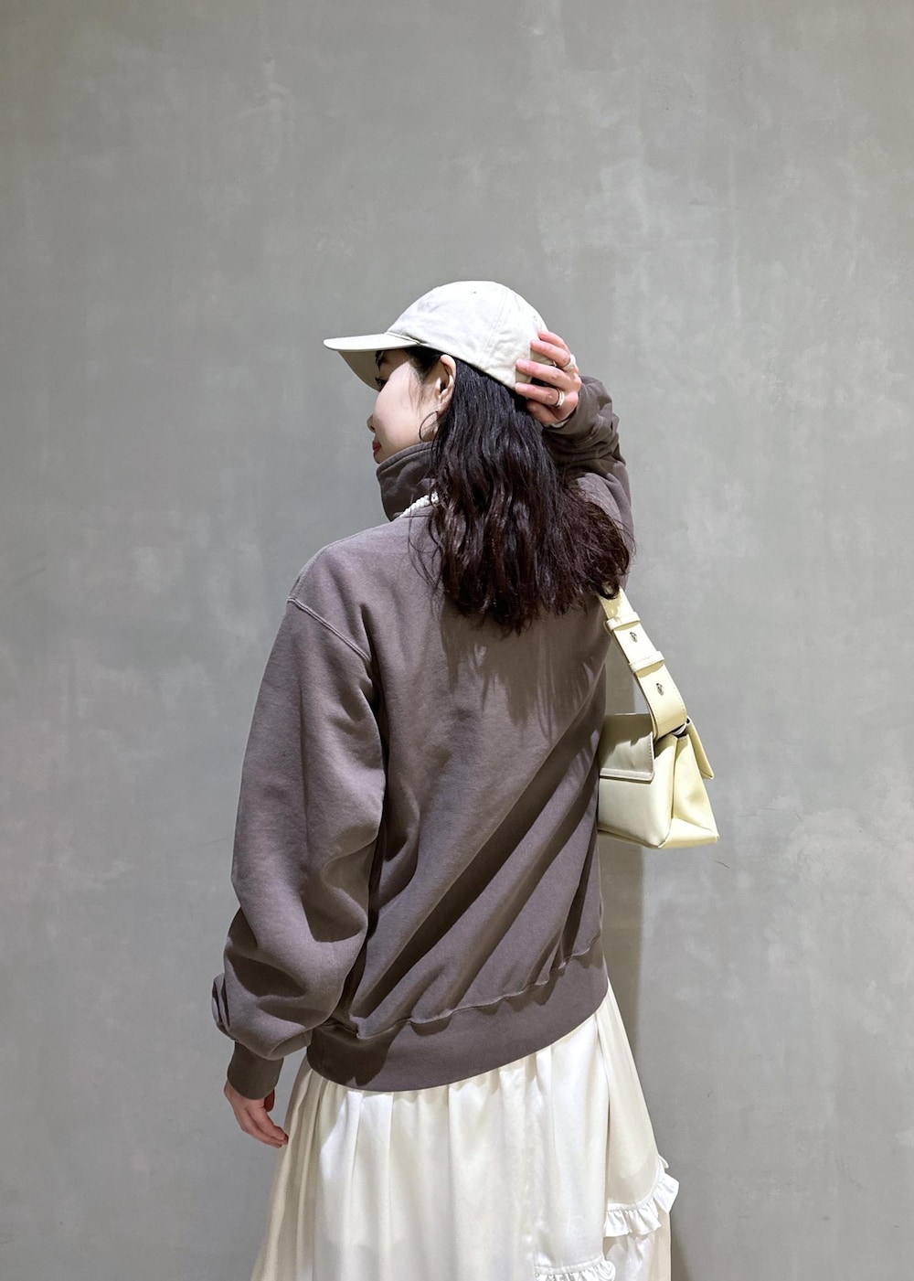 ホワイト系のスカート、ブラウン系のスウェット、ベージュ系のサンダルを着用したレディースの冬コーディネートの8枚目の写真