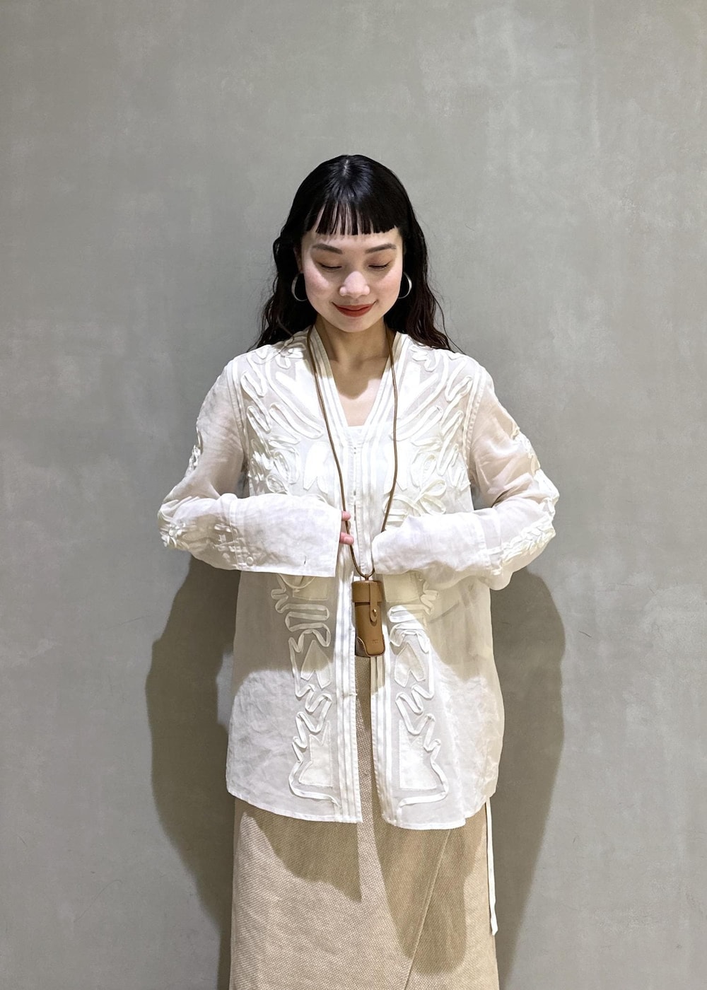 ベージュ系のスカート、ホワイト系のシャツ/ブラウス、ブルー系のデニムパンツを着用したレディースの冬コーディネートの6枚目の写真