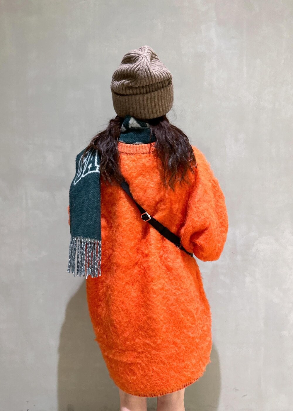 ベージュ系のトートバッグ、オレンジ系のワンピース、ブラウン系のシュシュを着用したレディースの秋コーディネートの10枚目の写真