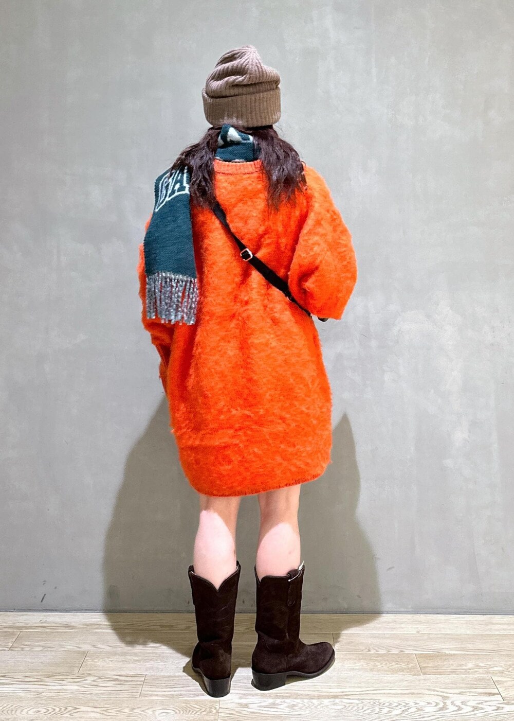 ベージュ系のトートバッグ、オレンジ系のワンピース、ブラウン系のシュシュを着用したレディースの秋コーディネートの4枚目の写真