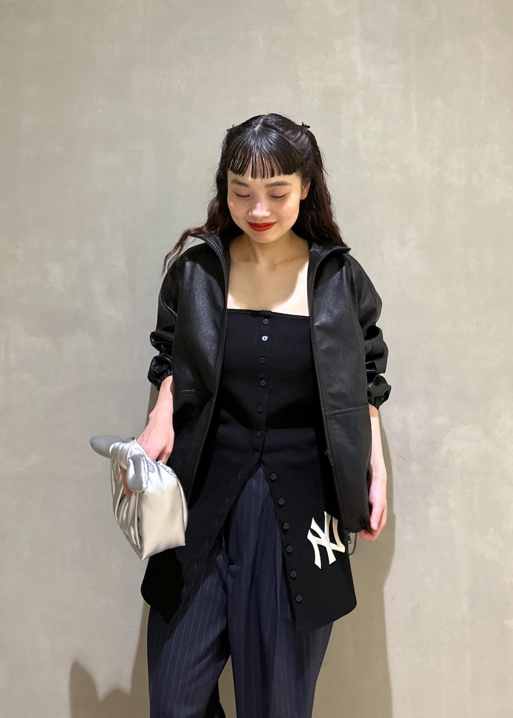 シルバー系のショルダーバッグ、シルバー系のブーツ、ブラック系のスラックスを着用したレディースの秋コーディネートの6枚目の写真