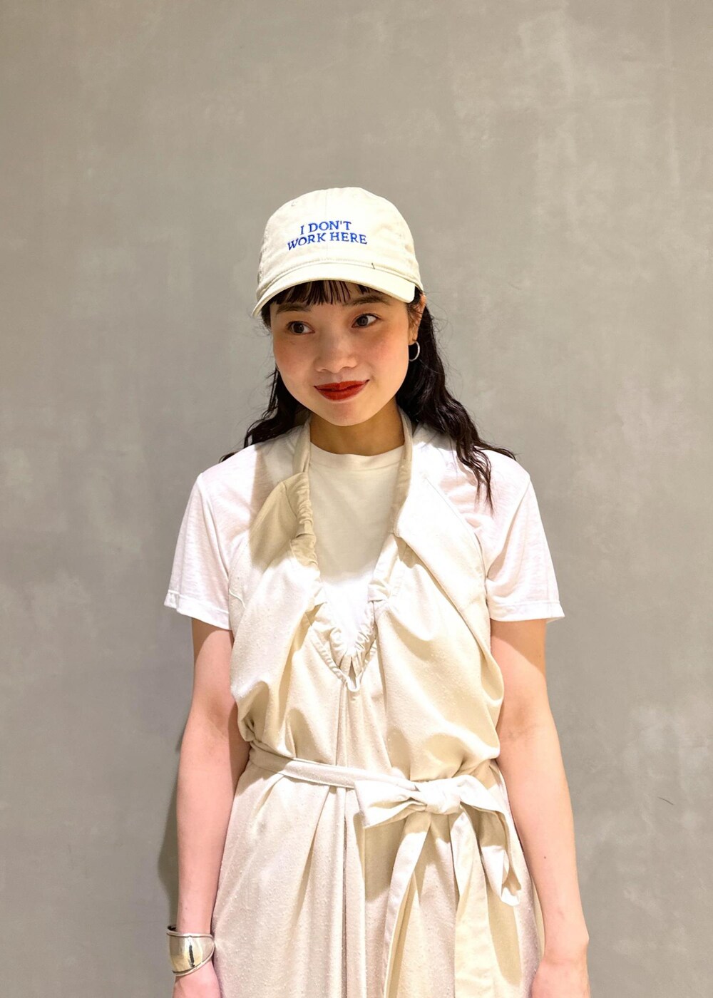 グレー系のショルダーバッグ、ベージュ系のスラックスを着用したレディースの夏コーディネートの7枚目の写真