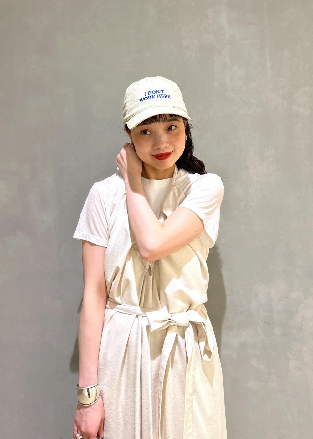 グレー系のショルダーバッグ、ベージュ系のスラックスを着用したレディースの夏コーディネートの4枚目の写真