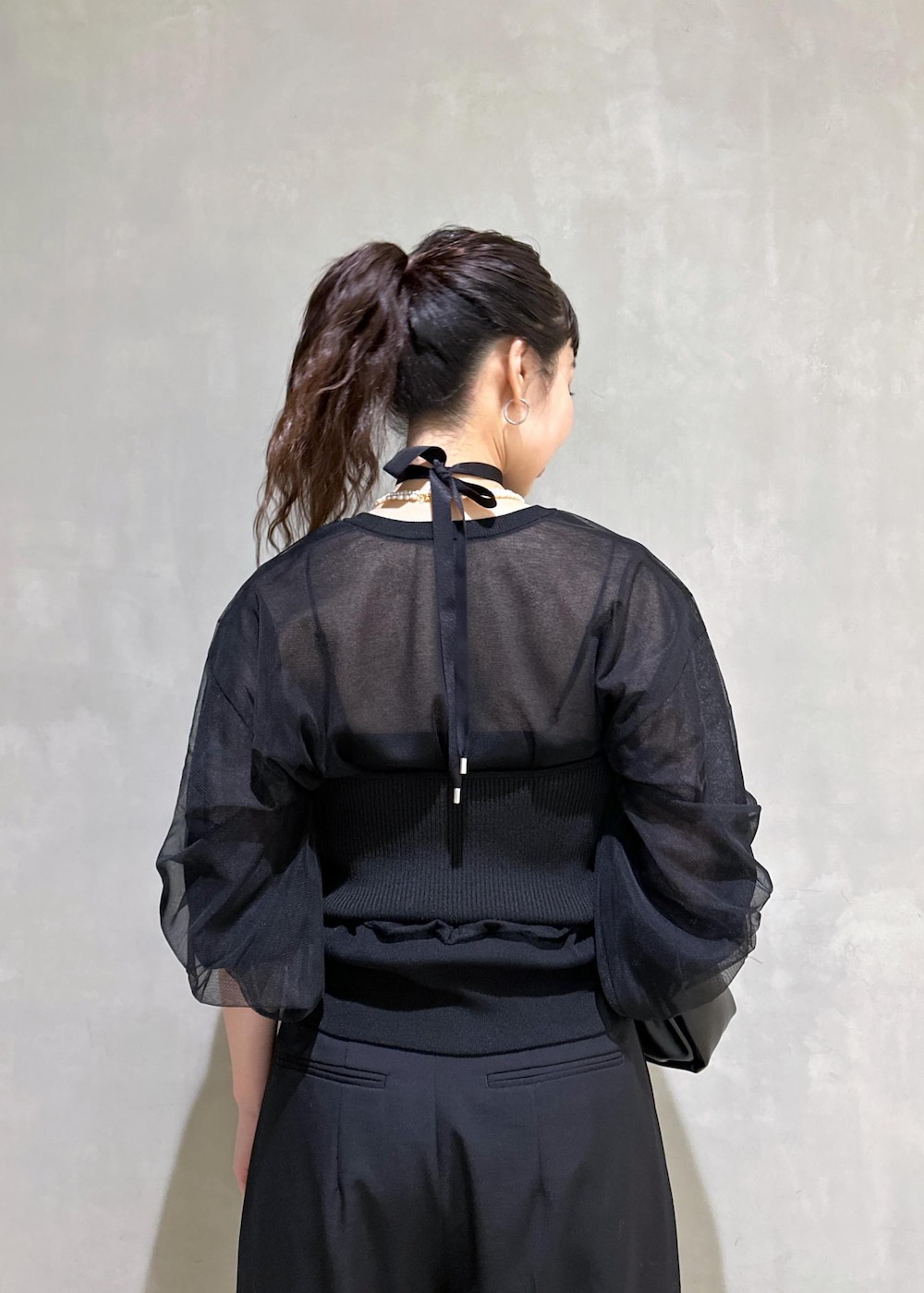 ブラック系のカーディガン/ボレロ、ブラック系のスラックス、ブラック系のショルダーバッグを着用したレディースの夏コーディネートの8枚目の写真