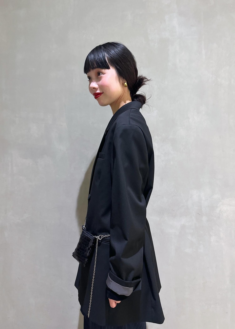 ブラック系のショルダーバッグ、ブラック系のテーラードジャケット、ブラック系のTシャツ/カットソーを着用したレディースの冬コーディネートの7枚目の写真