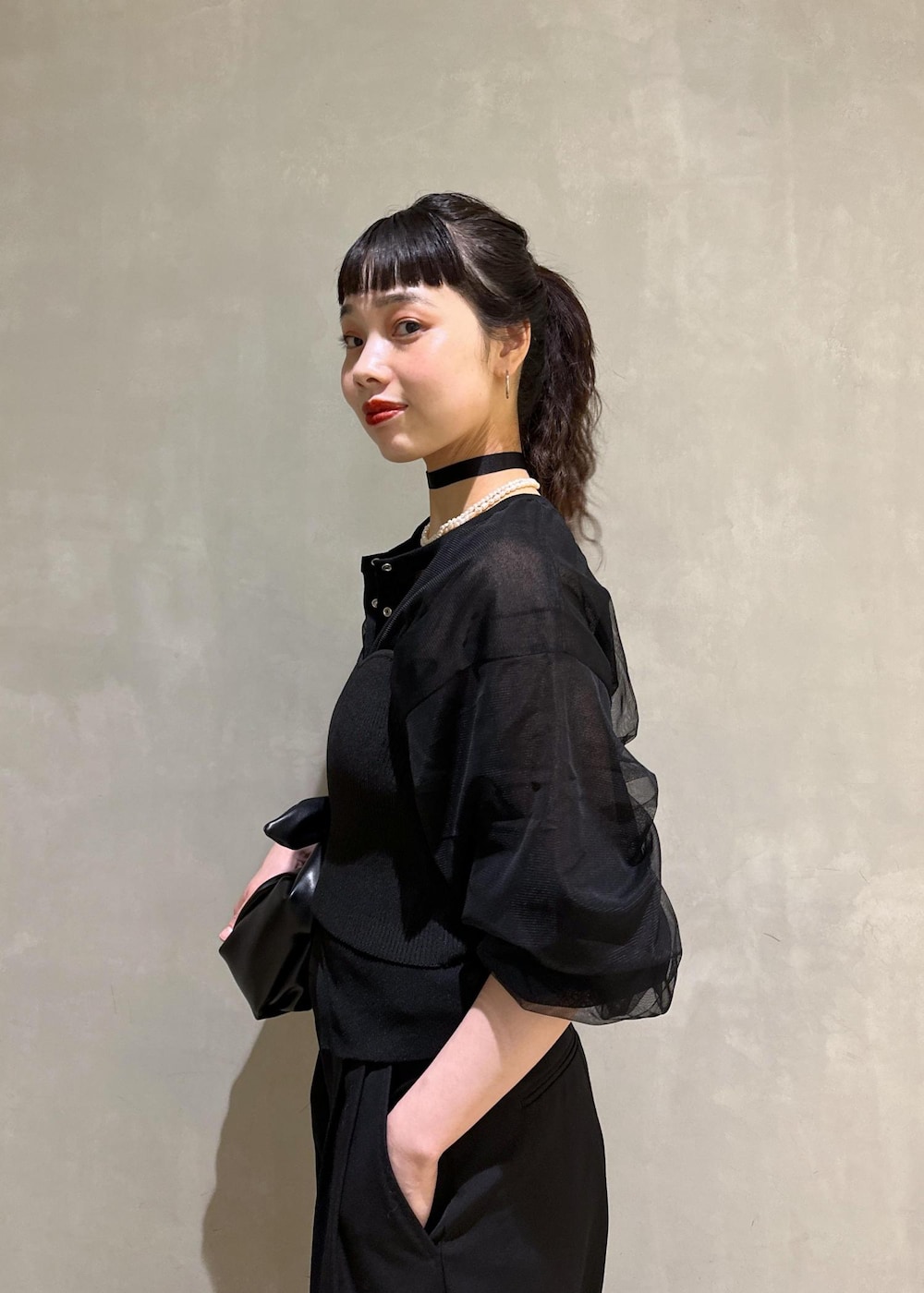 ブラック系のカーディガン/ボレロ、ブラック系のスラックス、ブラック系のショルダーバッグを着用したレディースの夏コーディネートの7枚目の写真