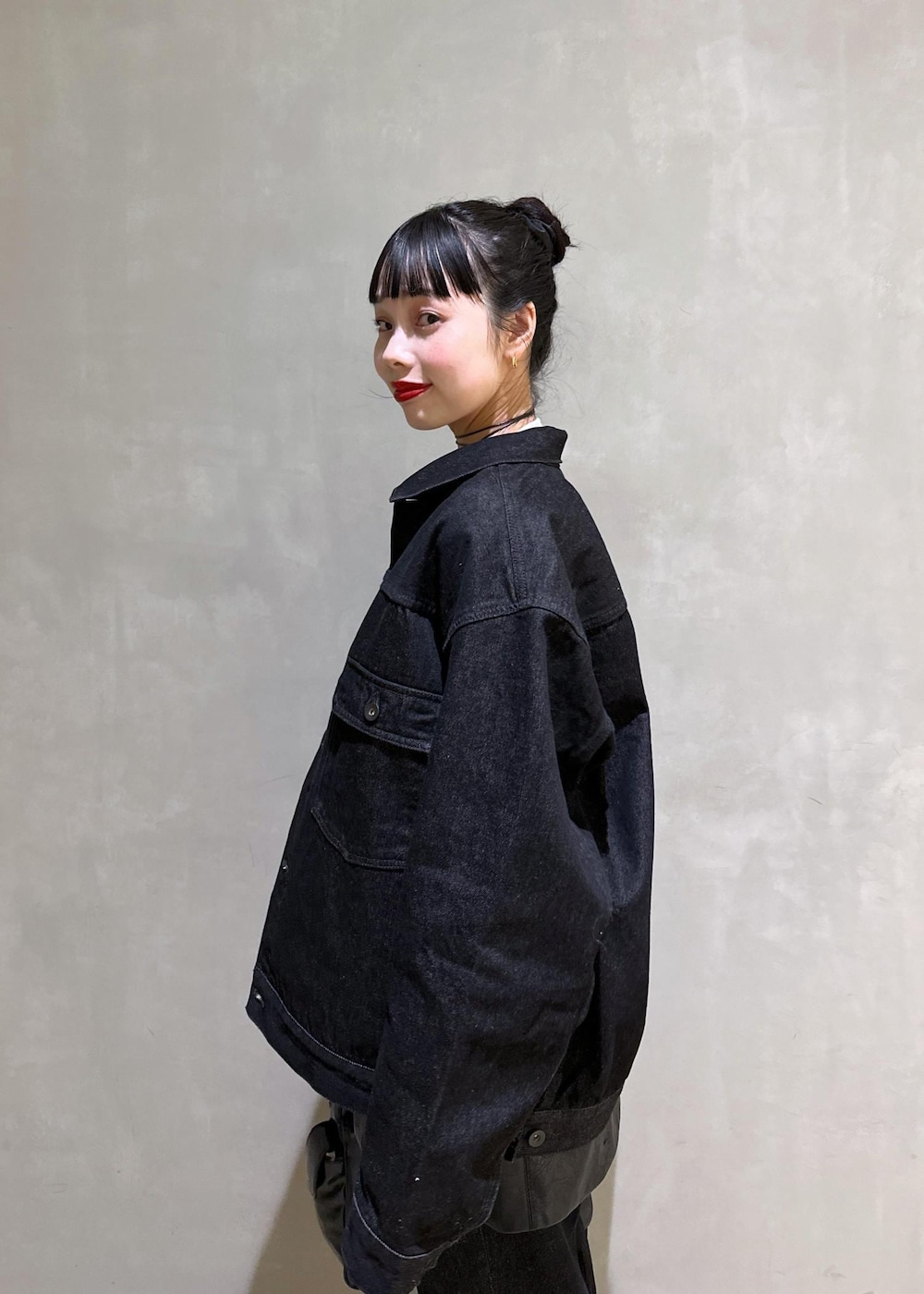 ブラック系のショルダーバッグ、ブラック系のデニムジャケット、ブラック系のデニムパンツを着用したレディースの冬コーディネートの9枚目の写真