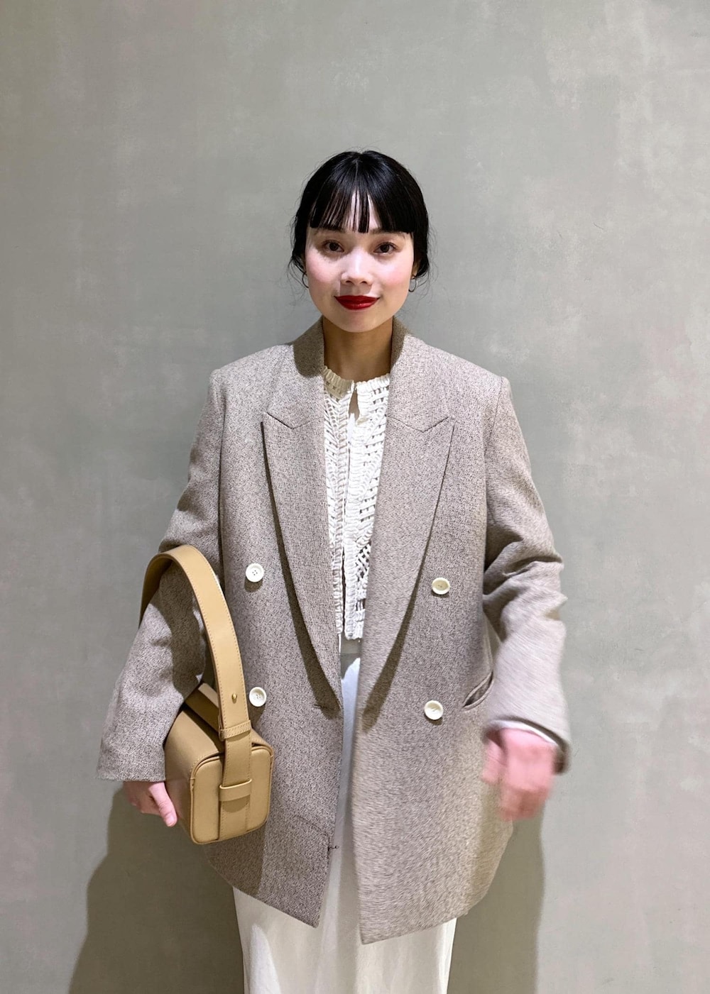 ホワイト系のTシャツ/カットソー、ベージュ系のその他アウター、ベージュ系のハンドバッグを着用したレディースの冬コーディネートの7枚目の写真