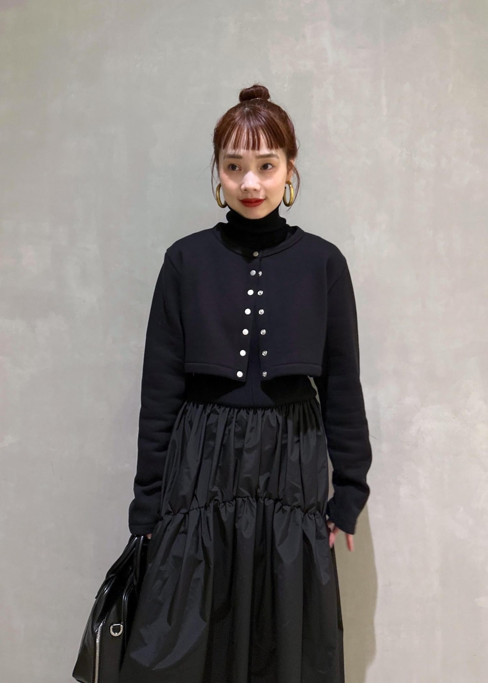 ブラック系のボストンバッグ、ブラック系のブーツ、ブラック系のカーディガン/ボレロを着用したレディースの秋コーディネートの4枚目の写真