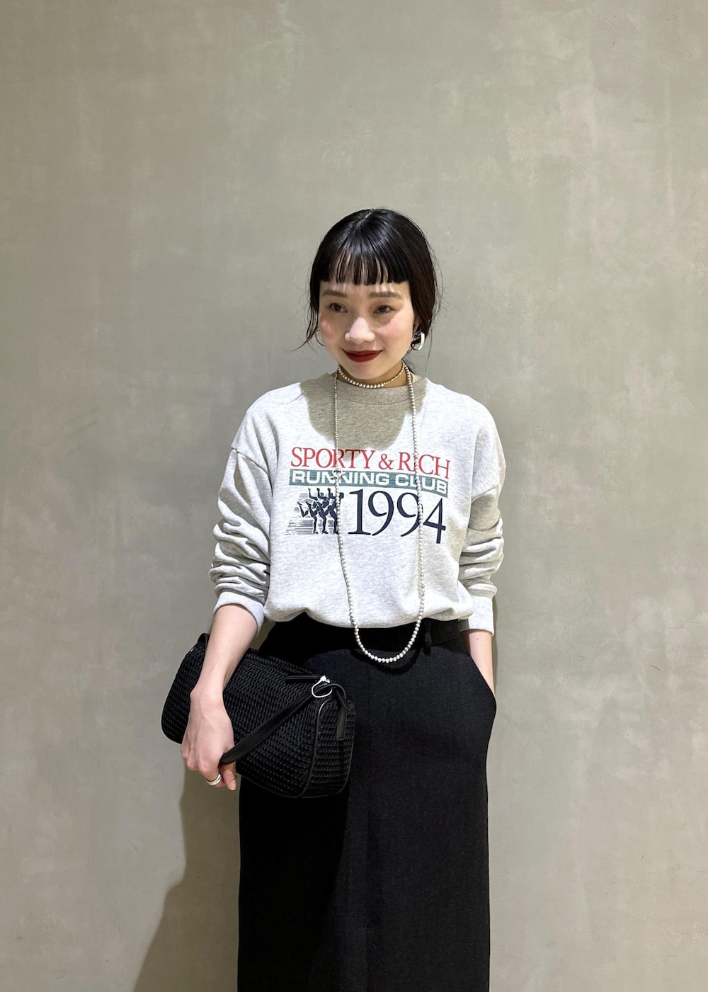 ブラック系のハンドバッグ、ブラック系のスカートを着用したレディースの秋コーディネートの9枚目の写真