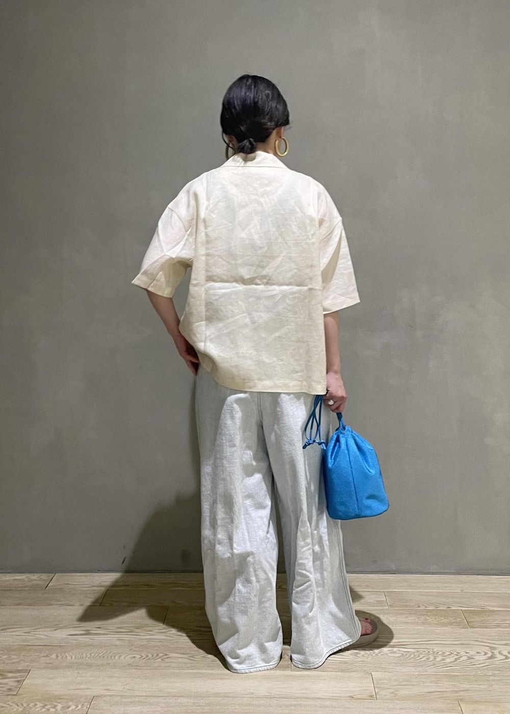 ホワイト系のサロペット/オーバーオール、ブルー系のショルダーバッグ、ベージュ系のサンダルを着用したレディースの春コーディネートの4枚目の写真