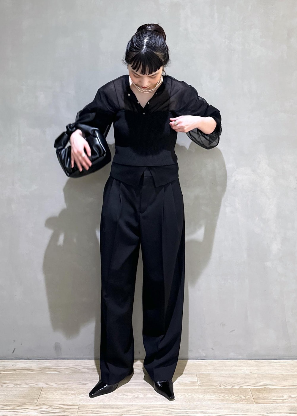 ブラック系のカーディガン/ボレロ、ブラック系のスラックス、ブラック系のショルダーバッグを着用したレディースの夏コーディネートの4枚目の写真