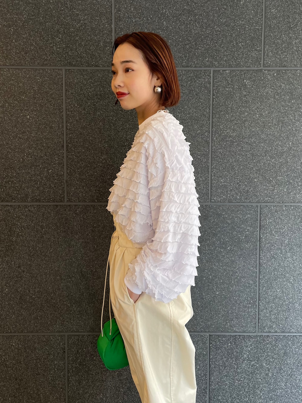 ホワイト系のTシャツ/カットソー、ホワイト系のパンツ、グリーン系のハンドバッグを着用したレディースの冬コーディネートの4枚目の写真