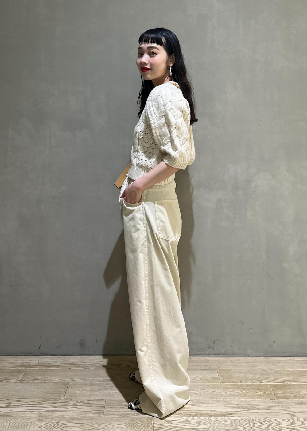 ホワイト系のその他パンツ、ホワイト系のニット/セーター、イエロー系のキーホルダーを着用したレディースの秋コーディネートの3枚目の写真