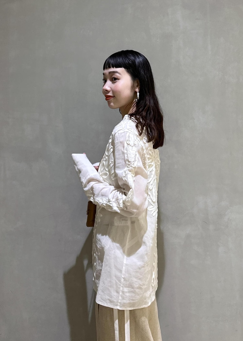 ベージュ系のスカート、ホワイト系のシャツ/ブラウス、ブルー系のデニムパンツを着用したレディースの冬コーディネートの7枚目の写真