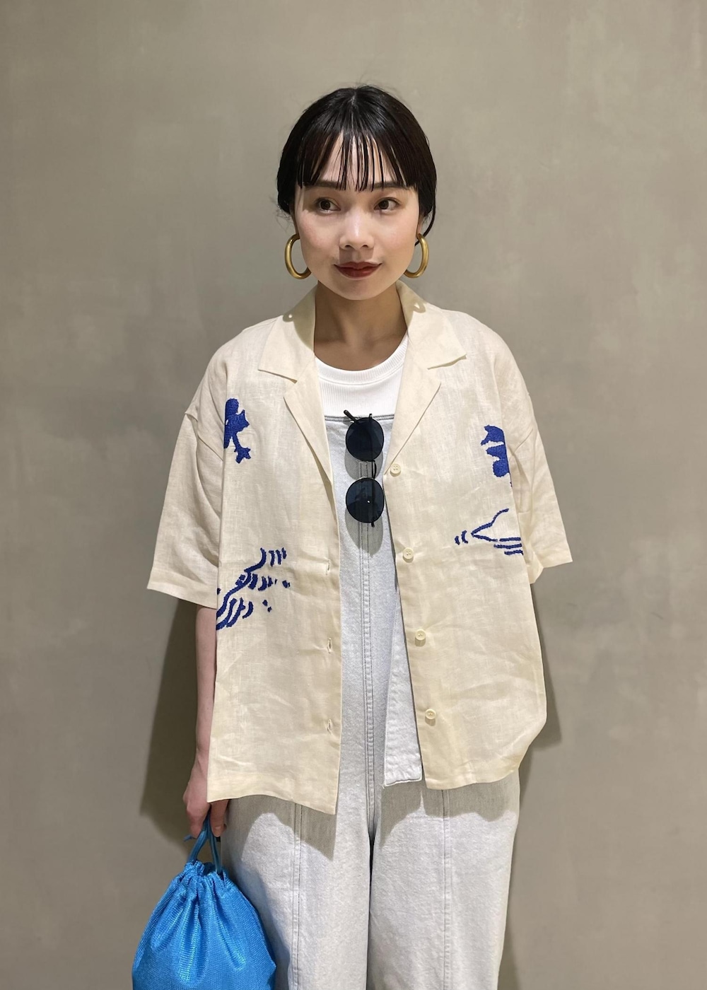 ホワイト系のサロペット/オーバーオール、ブルー系のショルダーバッグ、ベージュ系のサンダルを着用したレディースの春コーディネートの5枚目の写真