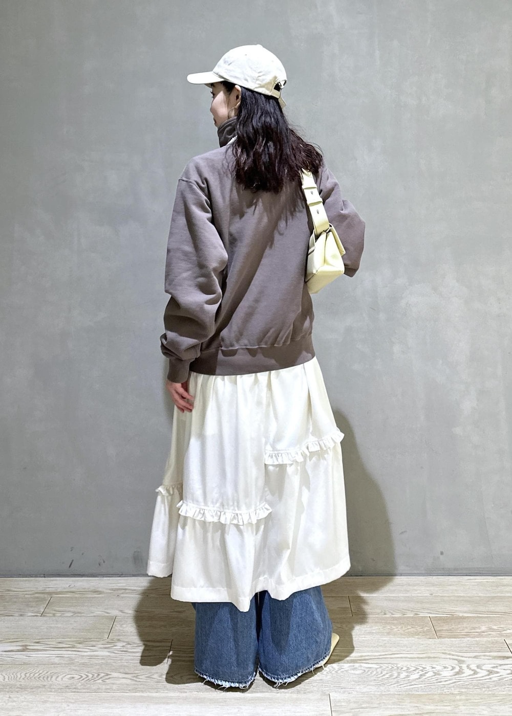 ホワイト系のスカート、ブラウン系のスウェット、ベージュ系のサンダルを着用したレディースの冬コーディネートの4枚目の写真