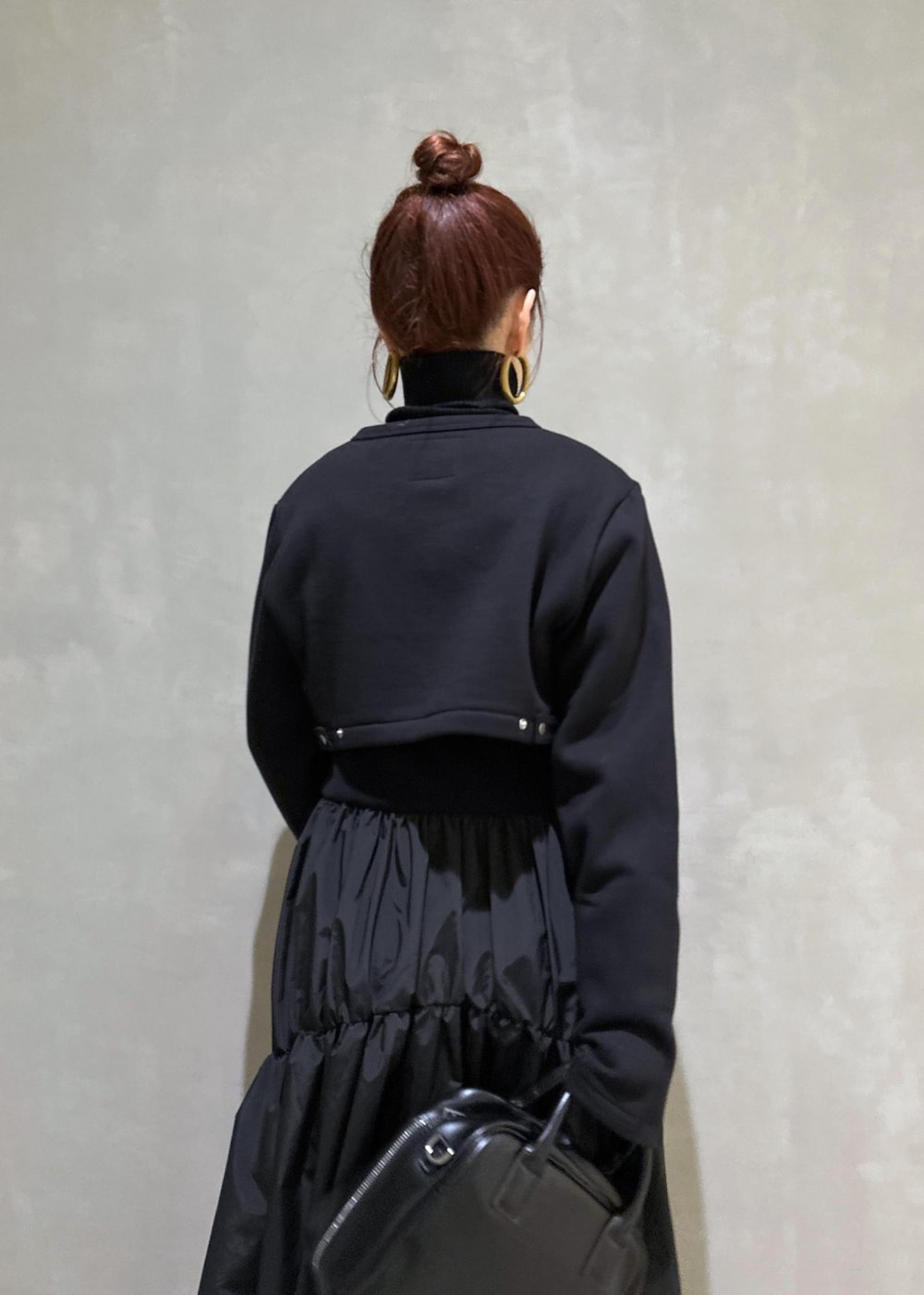 ブラック系のボストンバッグ、ブラック系のブーツ、ブラック系のカーディガン/ボレロを着用したレディースの秋コーディネートの7枚目の写真