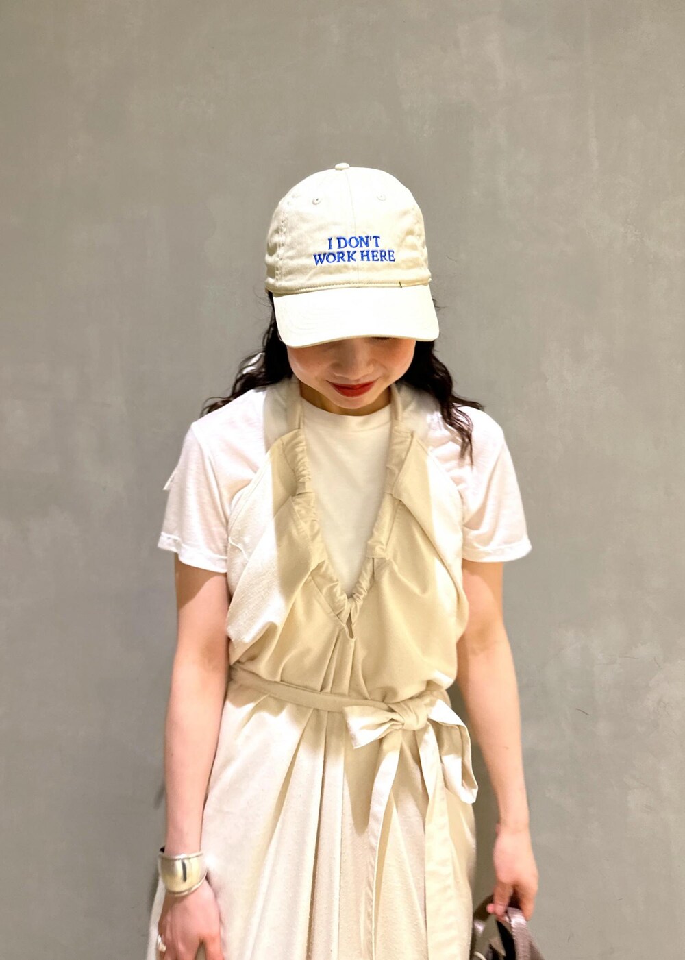 グレー系のショルダーバッグ、ベージュ系のスラックスを着用したレディースの夏コーディネートの6枚目の写真