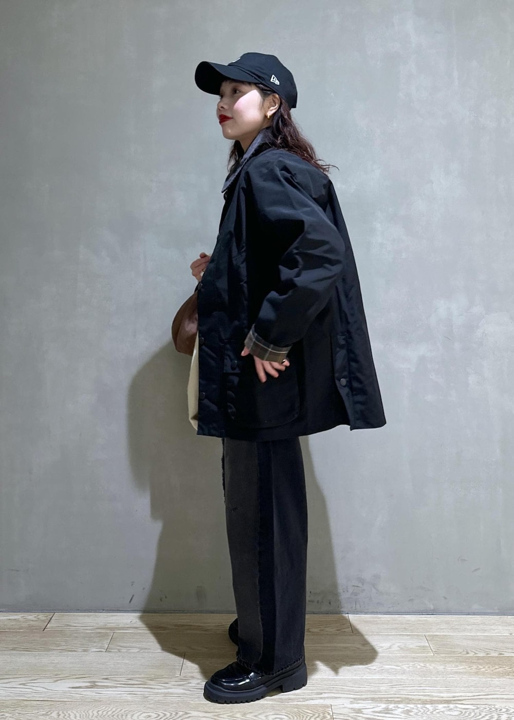 ブラック系のブルゾン、ブラック系のローファー、ブラック系のデニムパンツを着用したレディースの冬コーディネートの4枚目の写真