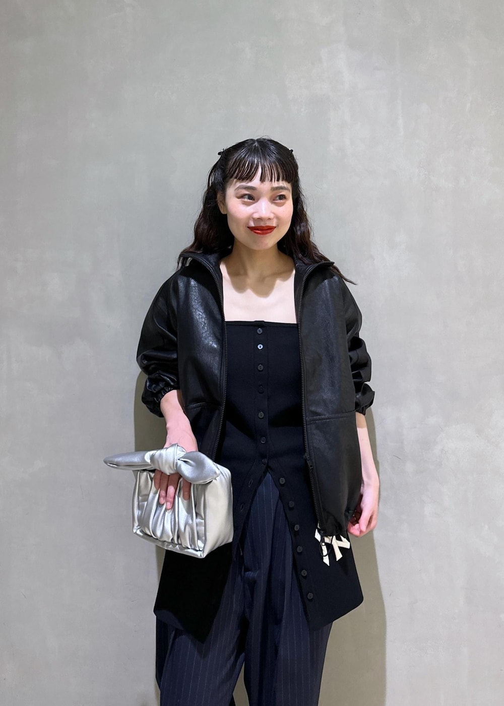 シルバー系のショルダーバッグ、シルバー系のブーツ、ブラック系のスラックスを着用したレディースの秋コーディネートの7枚目の写真