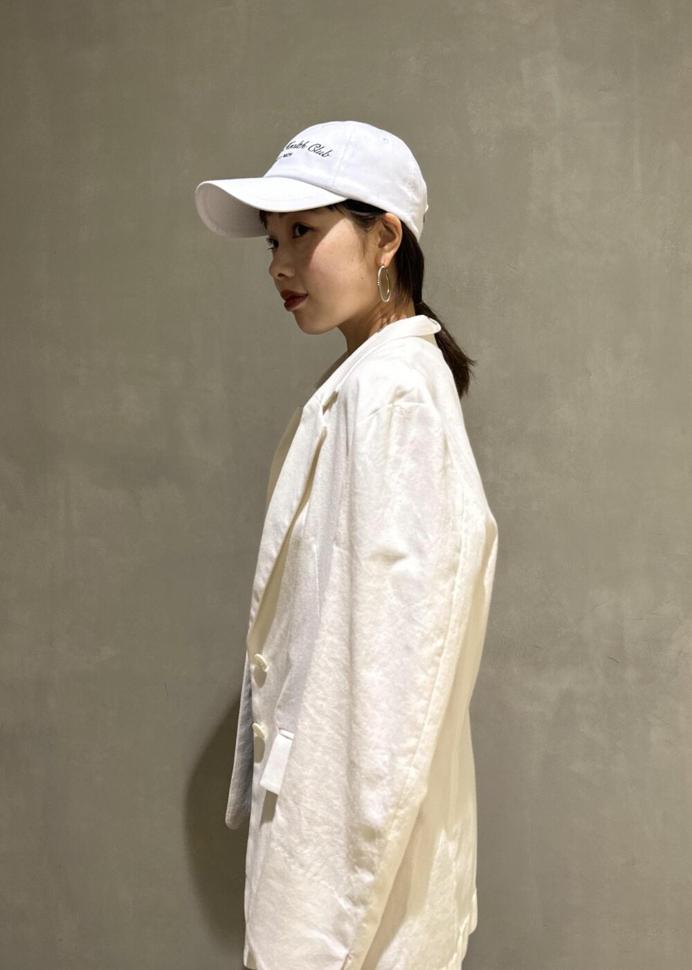 ホワイト系のタンクトップ、ホワイト系のテーラードジャケット、ブラック系のハンドバッグを着用したレディースの夏コーディネートの5枚目の写真