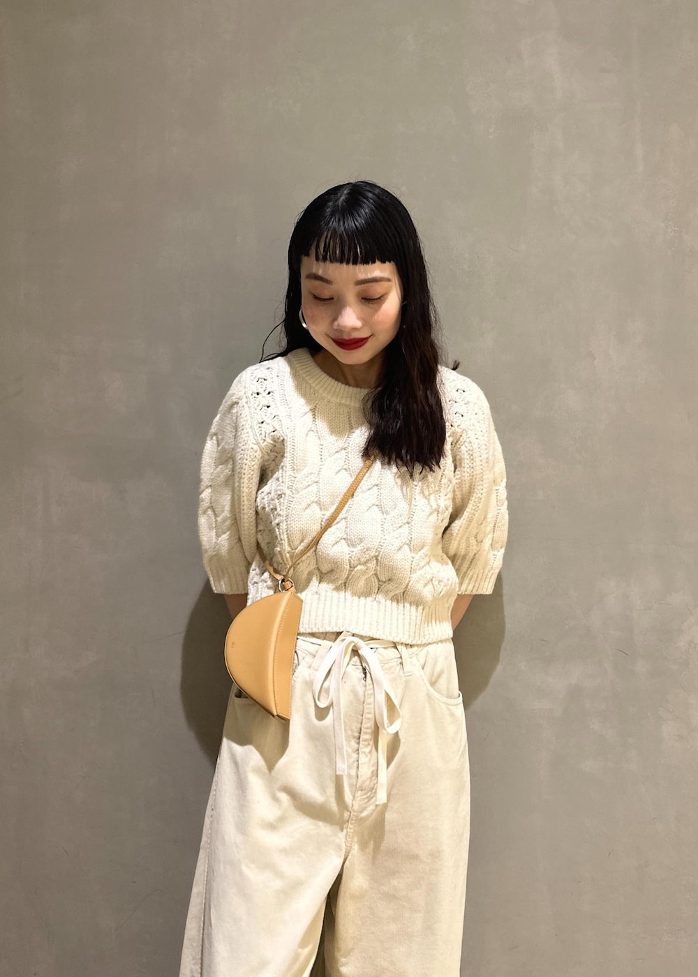 ホワイト系のその他パンツ、ホワイト系のニット/セーター、イエロー系のキーホルダーを着用したレディースの秋コーディネートの7枚目の写真