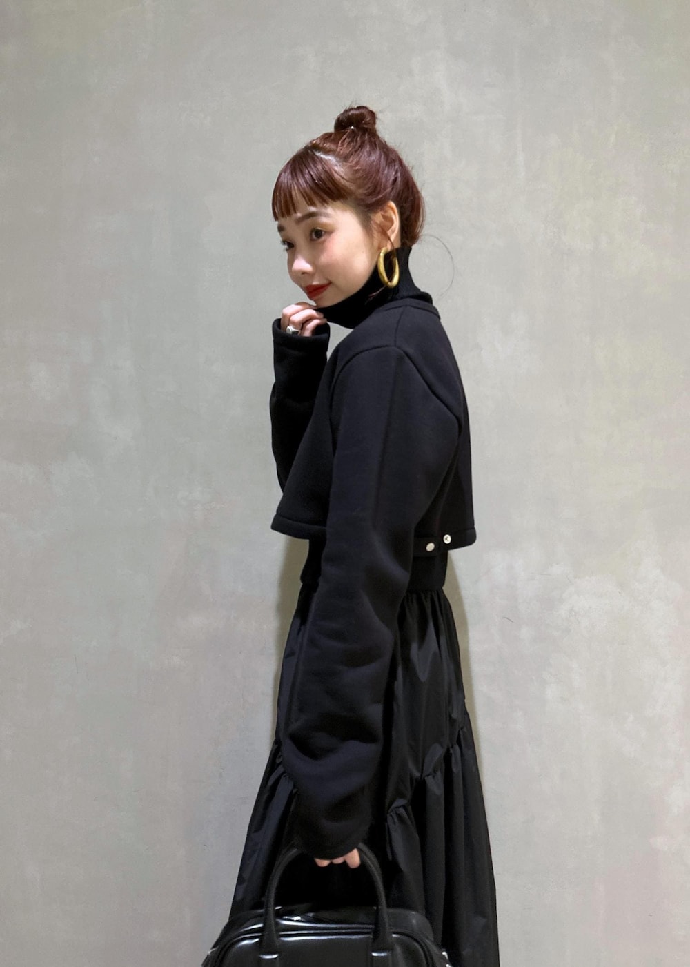 ブラック系のボストンバッグ、ブラック系のブーツ、ブラック系のカーディガン/ボレロを着用したレディースの秋コーディネートの5枚目の写真