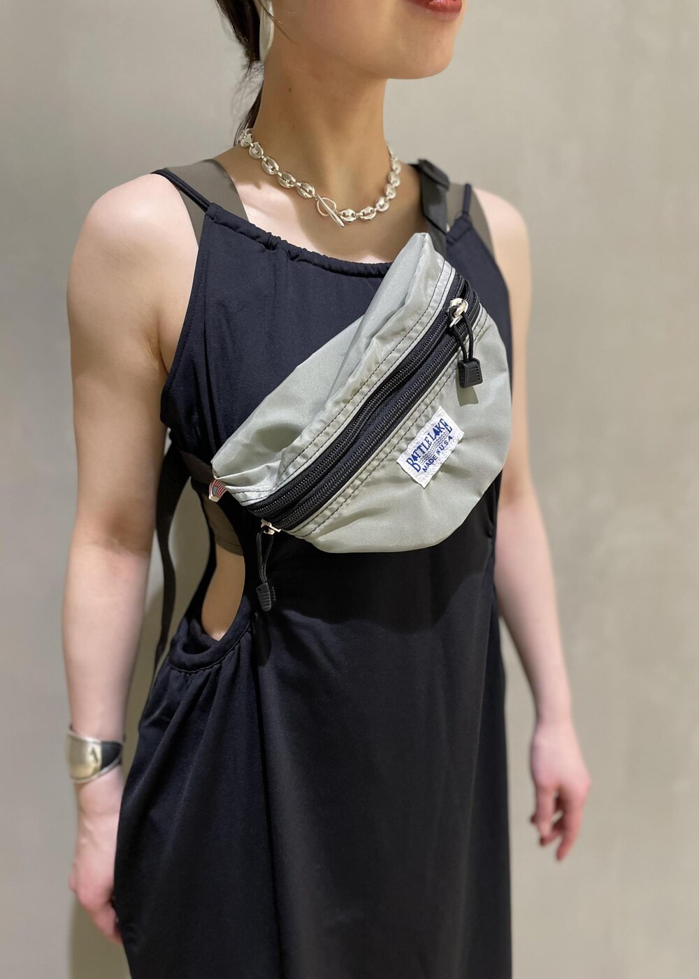 グレー系のボディバッグ/ウエストポーチ、ブラック系のブーツ、ブラック系のワンピースを着用したレディースの春コーディネートの8枚目の写真