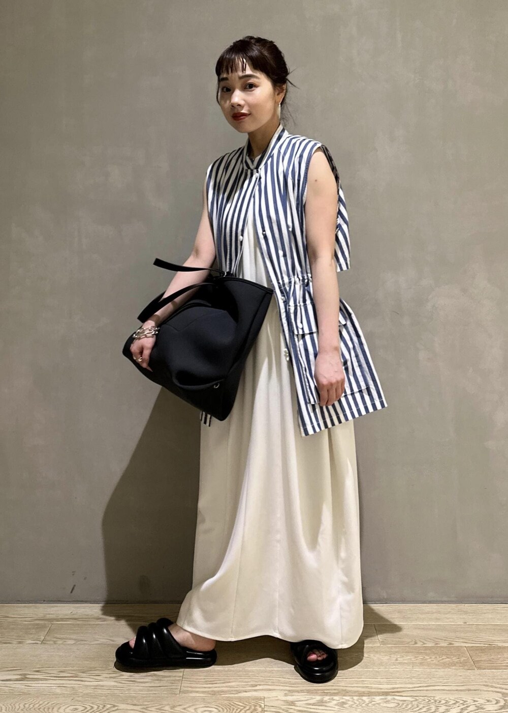 ブラック系のトートバッグ、ホワイト系のシャツ/ブラウス、ホワイト系のワンピースを着用したレディースの夏コーディネートの2枚目の写真
