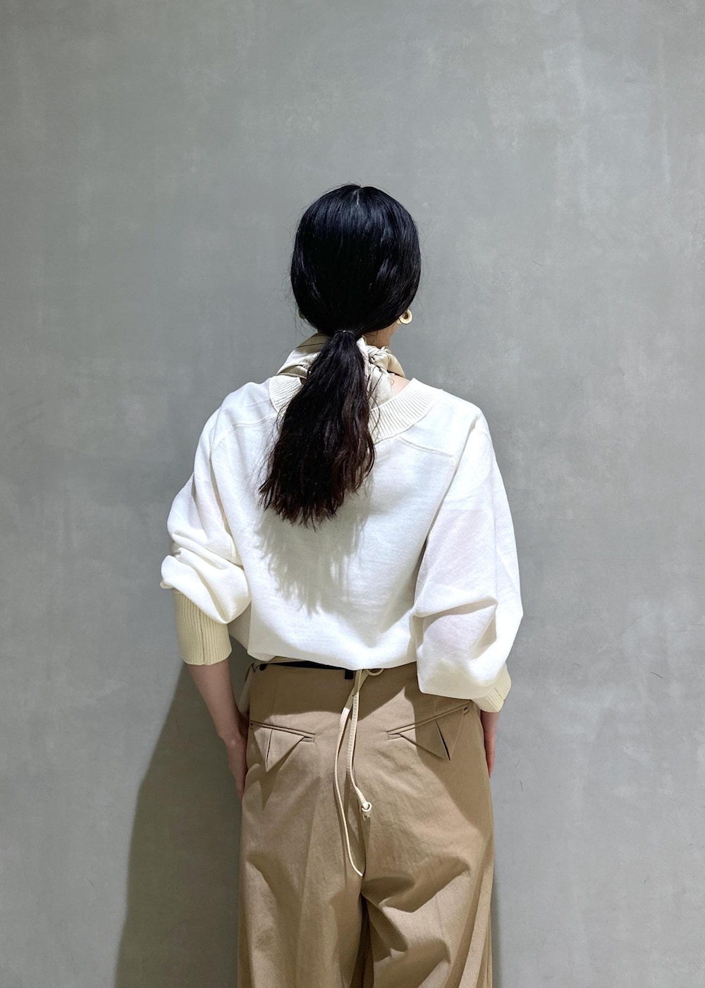ベージュ系のショルダーバッグ、ベージュ系のブーツ、イエロー系のその他パンツを着用したレディースの秋コーディネートの10枚目の写真