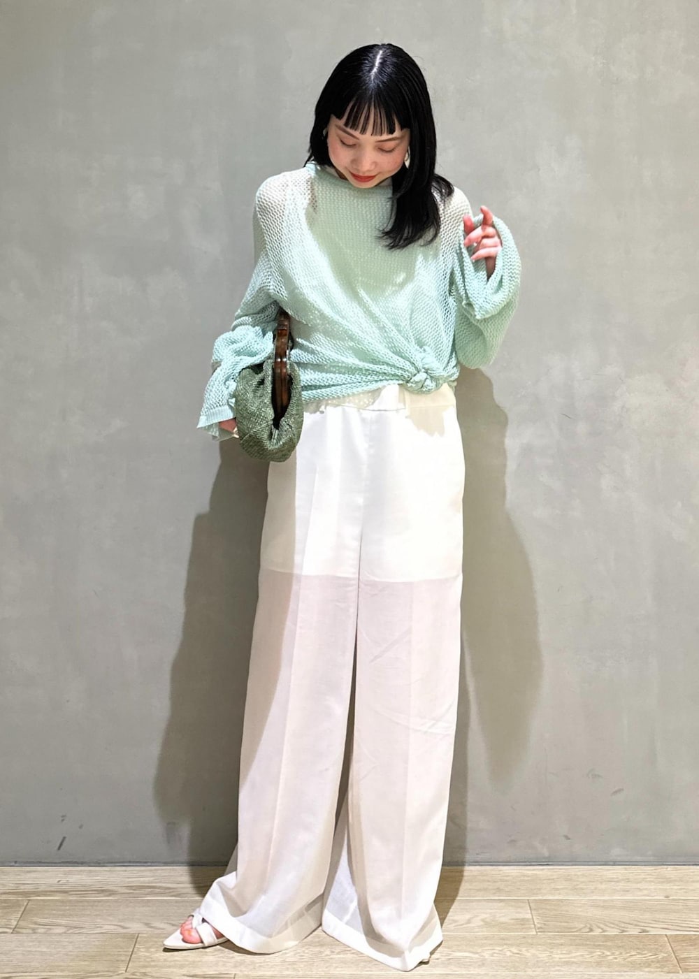 ホワイト系のサンダル、ホワイト系のサロペット/オーバーオール、グリーン系のクラッチバッグを着用したレディースの春コーディネートの2枚目の写真