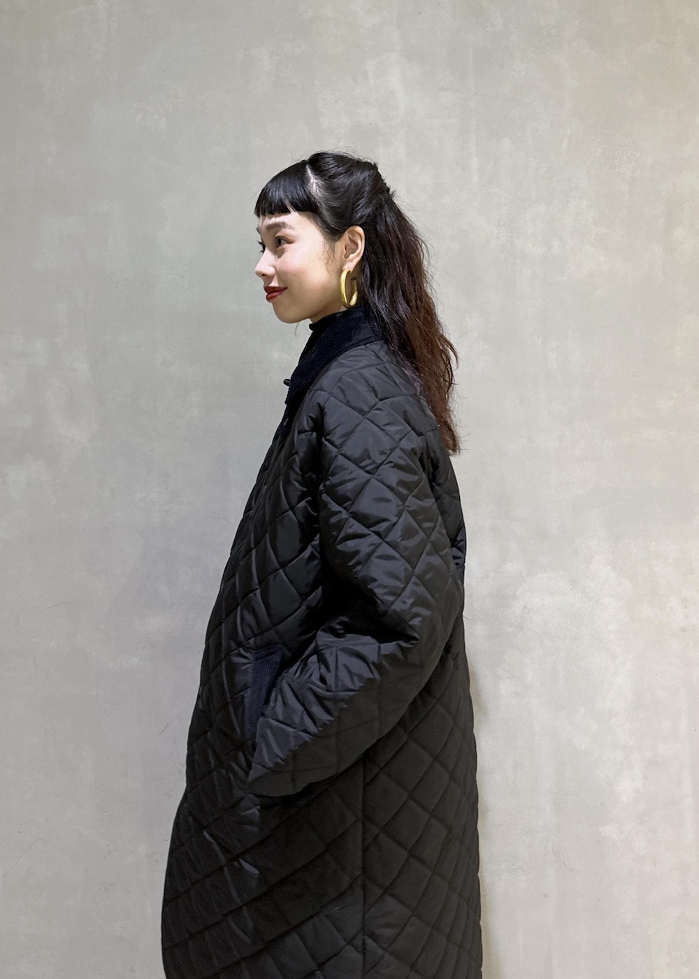 ブラック系のニット/セーター、ブラック系のナイロンジャケット、ブラック系のブーツを着用したレディースの秋コーディネートの7枚目の写真