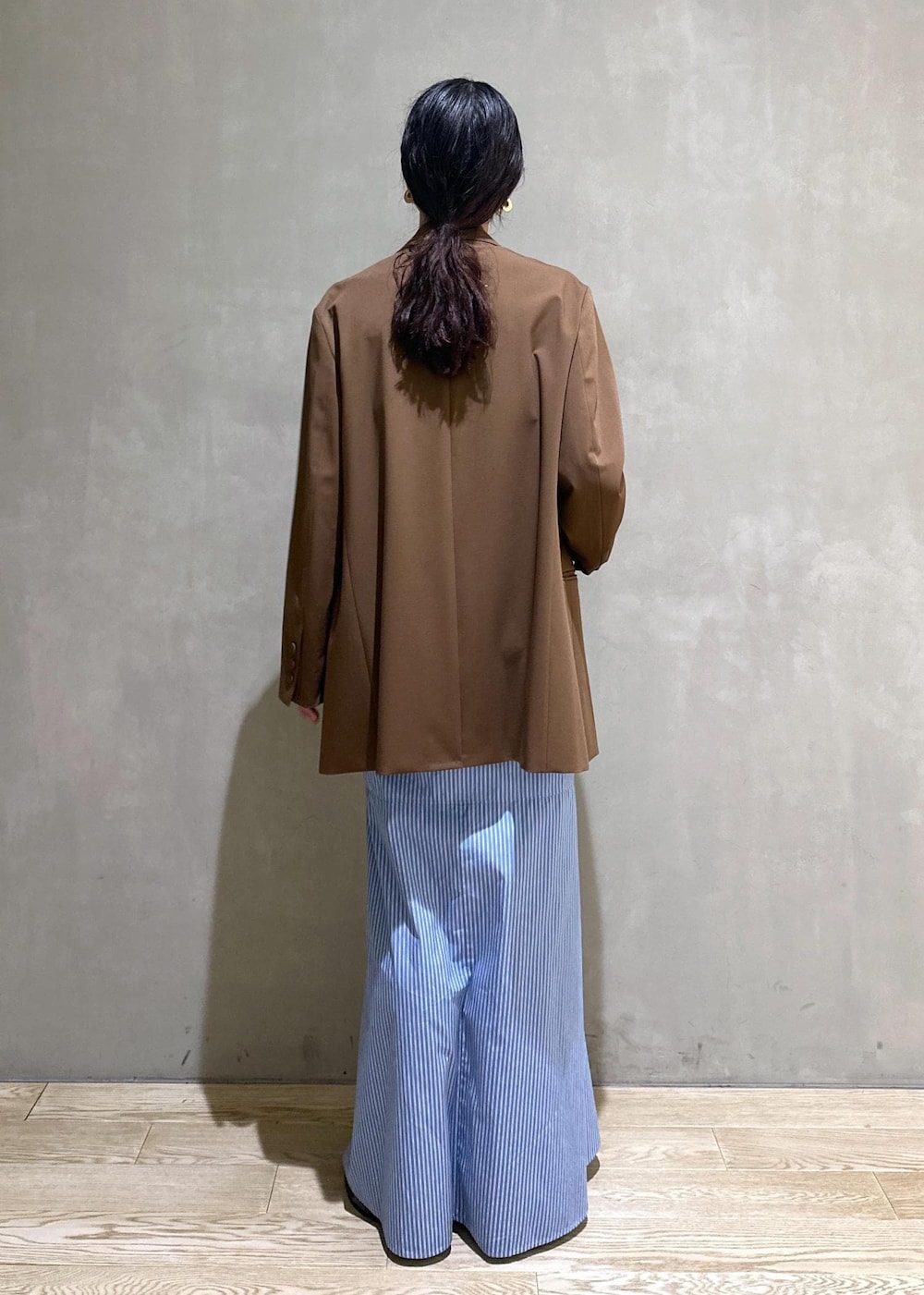 ブラック系のサンダル、ブラウン系のテーラードジャケット、ブルー系のシャツワンピースを着用したレディースの秋コーディネートの4枚目の写真