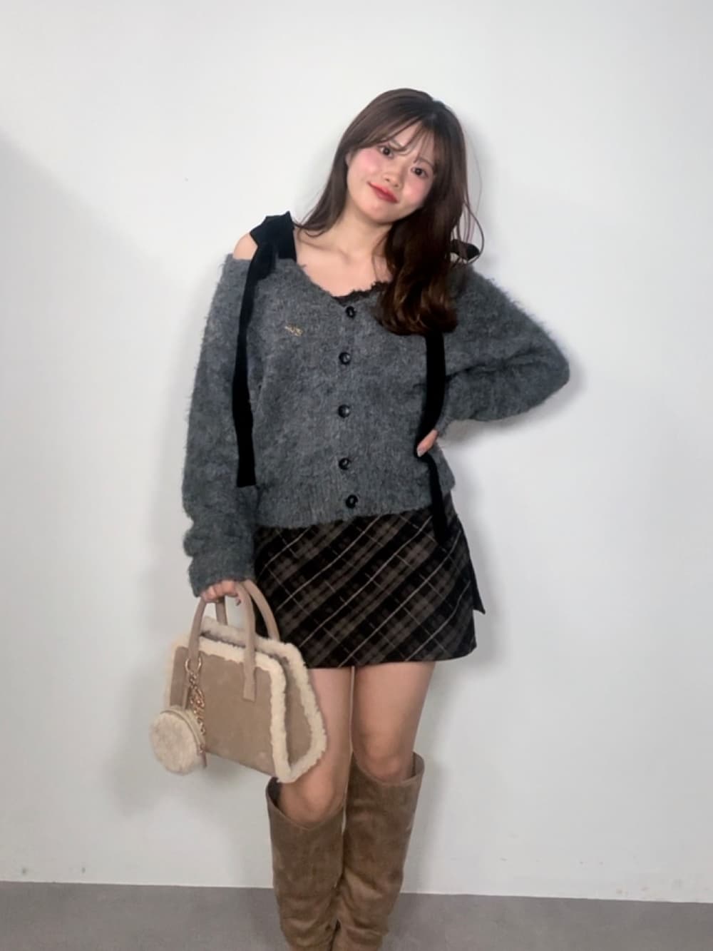 グレー系のカーディガン/ボレロ、ベージュ系のスカート、ベージュ系のブーツを着用したレディースの秋コーディネートの2枚目の写真