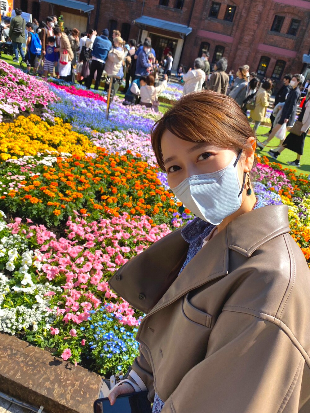 ベージュ系のその他アウター、ブルー系のワンピース、ブルー系のパンツを着用したレディースの春コーディネートの2枚目の写真