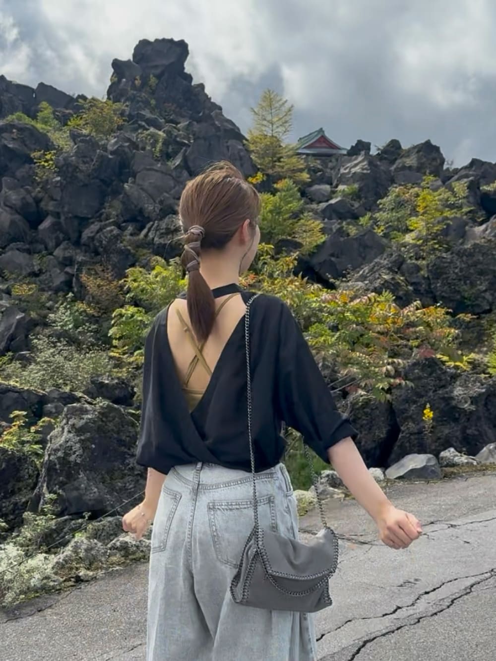 グレー系のデニムパンツ、ブラック系のシャツ/ブラウス、イエロー系のキャミソールを着用したレディースの秋コーディネートの2枚目の写真