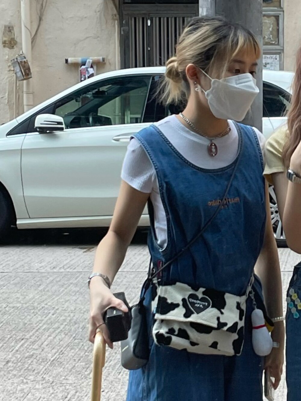 ブラック系のショルダーバッグ、ホワイト系のサンダル、ブルー系のワンピースを着用したレディースの春コーディネートの3枚目の写真