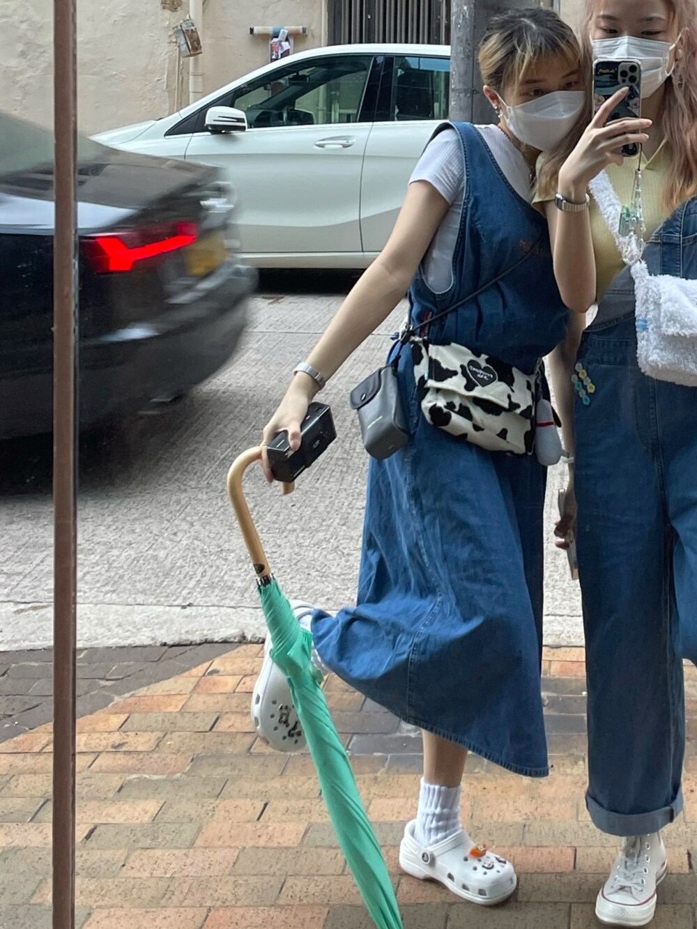 ブラック系のショルダーバッグ、ホワイト系のサンダル、ブルー系のワンピースを着用したレディースの春コーディネートの2枚目の写真