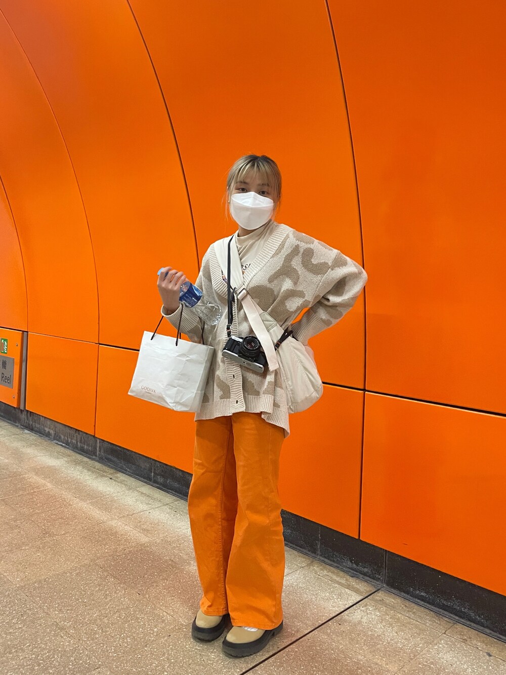 ベージュ系のカーディガン/ボレロ、ベージュ系のシューズ、オレンジ系のその他パンツを着用したレディースの春コーディネートの2枚目の写真