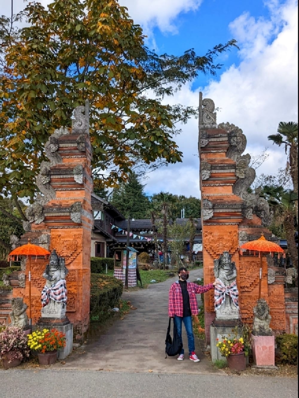 レッド系のシャツ/ブラウス、ブルー系のデニムパンツ、レッド系のスニーカーを着用したレディースの秋コーディネートの5枚目の写真