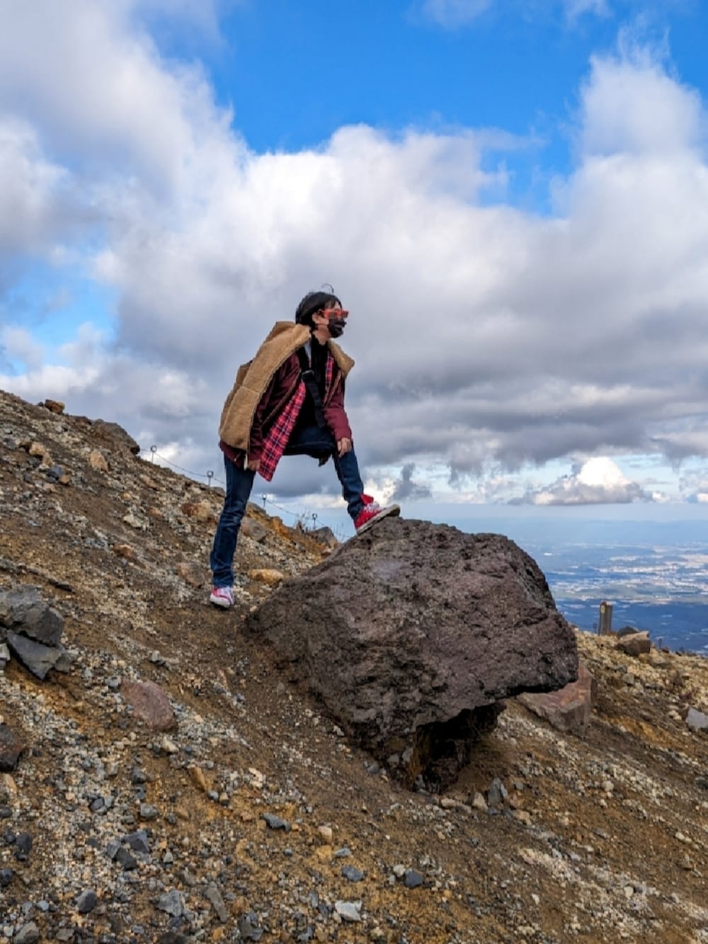 レッド系のシャツ/ブラウス、ブルー系のデニムパンツ、レッド系のスニーカーを着用したレディースの秋コーディネートの3枚目の写真