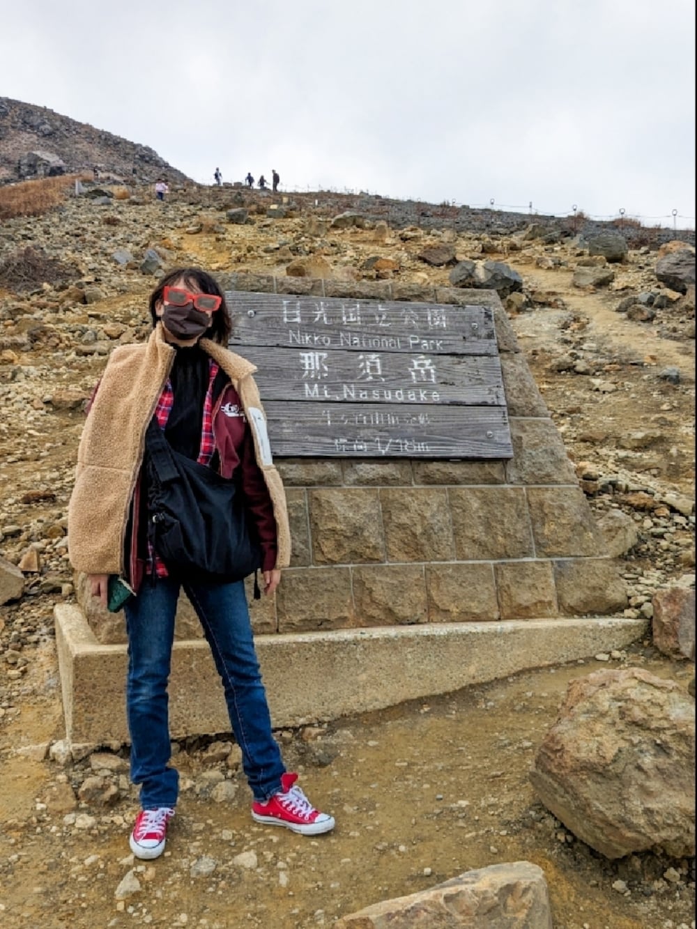 レッド系のシャツ/ブラウス、ブルー系のデニムパンツ、レッド系のスニーカーを着用したレディースの秋コーディネートの2枚目の写真